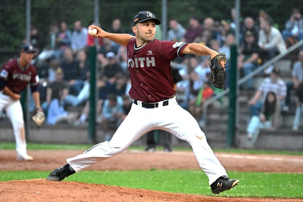 Logan Hofmann mid-delivery on the mound, body in motion as he releases a pitch during a game.