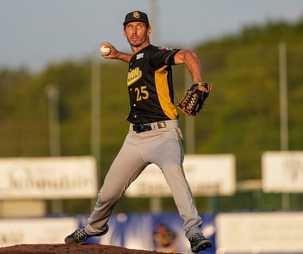 Markus Solbach delivering a pitch from the mound, arm extended forward with focus toward the catcher.