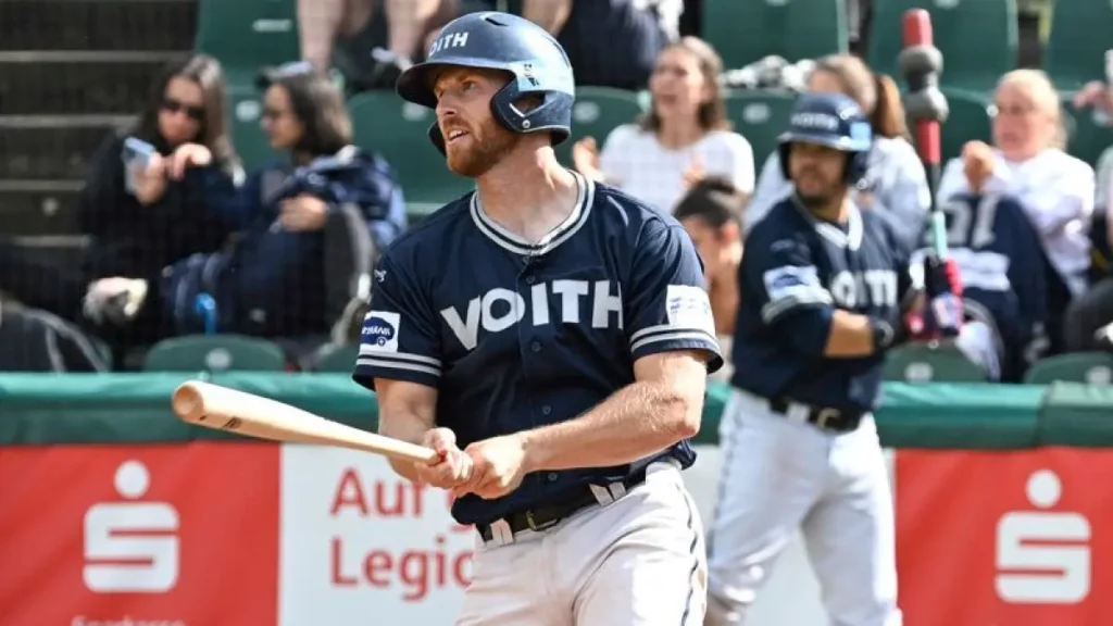 William Germaine rounding the bases after a hit, wearing a batting helmet and looking toward the next base.