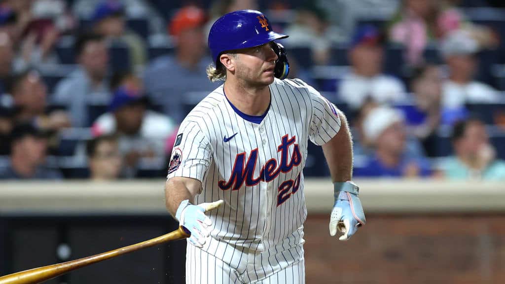 Baseball player in a New York Mets uniform swinging the bat during a game at Citi Field.