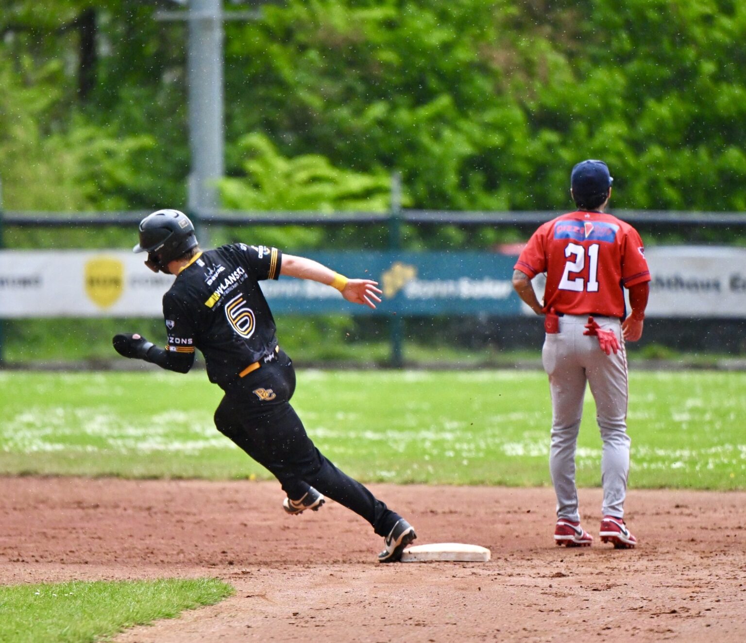 Baseball player rounding base at full speed during game action