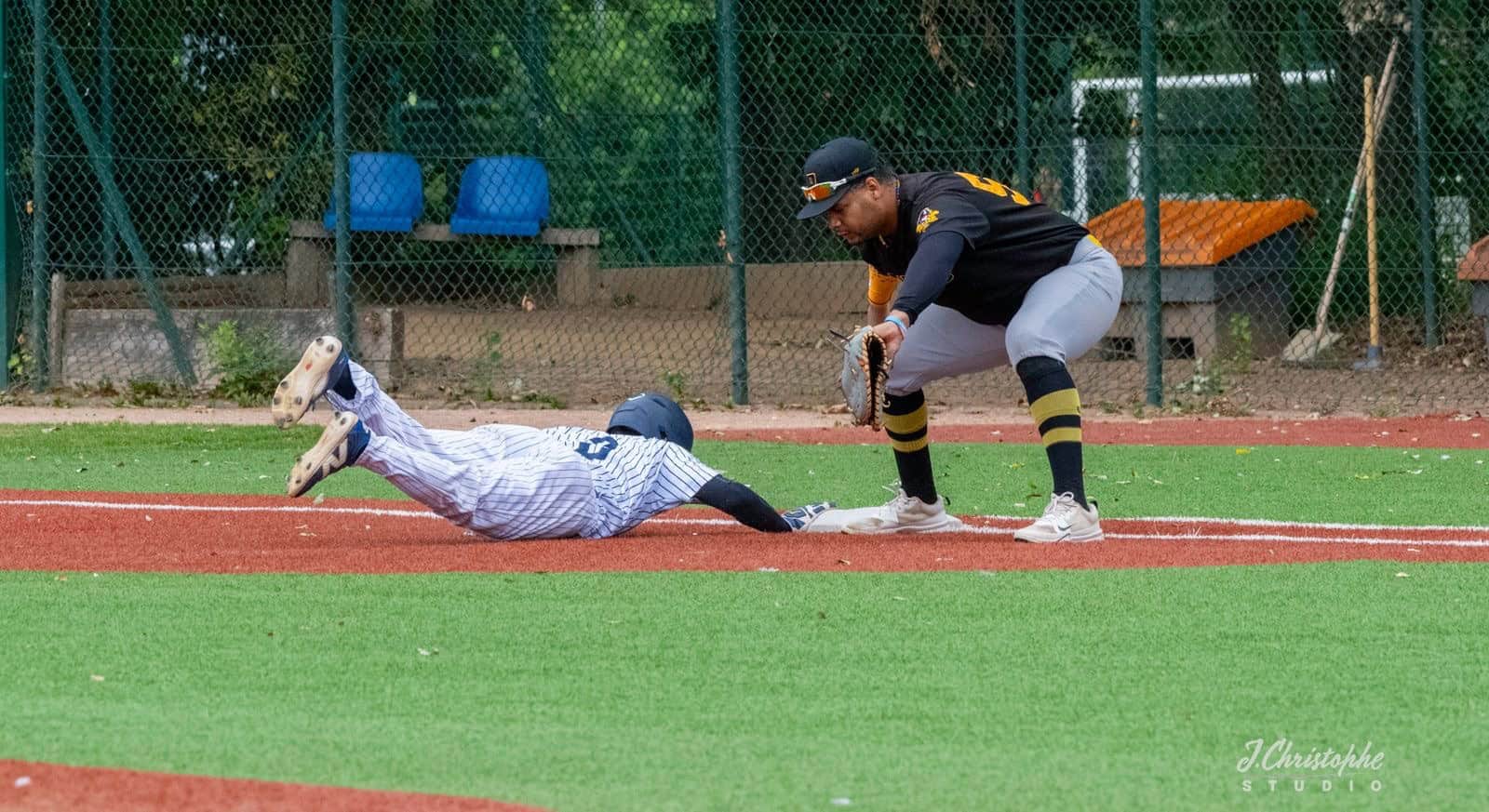 Baseball player sliding into base during a game at the baseball field.