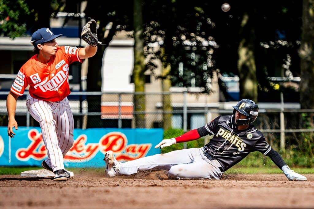 Oosterhout Twins vs Amsterdam Pirates – 2026 Hoofdklasse Playoffs Oosterhout Twins infielder receives a throw as an Amsterdam Pirates runner slides during the 2026 Honkbal Hoofdklasse playoffs.