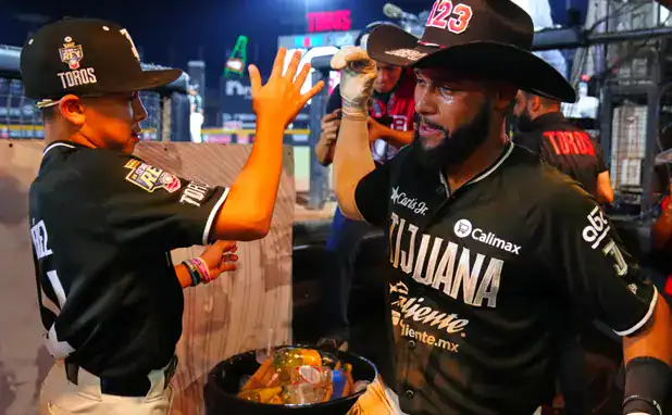 Toros de Tijuana player celebrates with a young fan during the 2026 Serie del Rey
