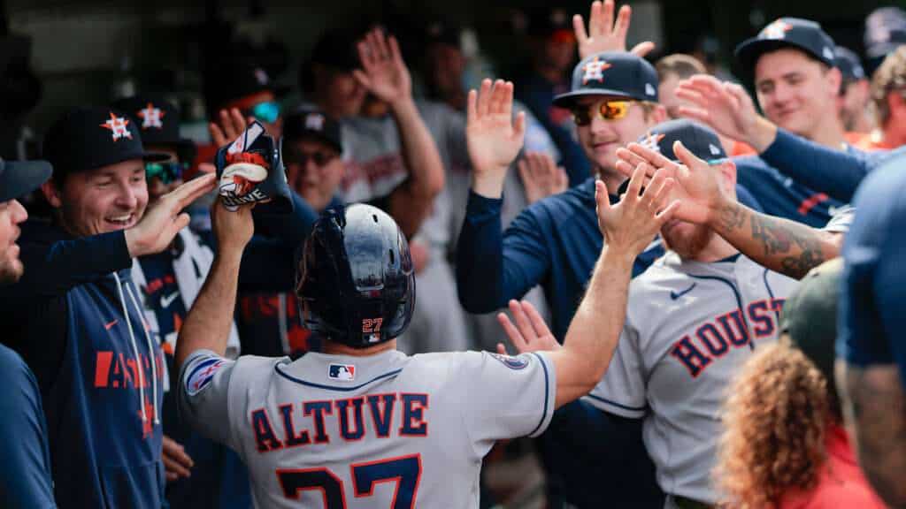 Jose Altuve high-fives Houston Astros teammates in the dugout