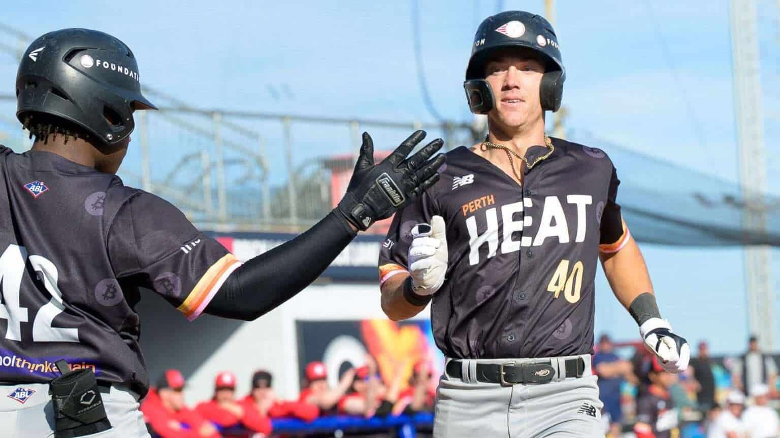 Perth Heat player in black jersey and batting helmet celebrates with a teammate during an Australian Baseball League game
