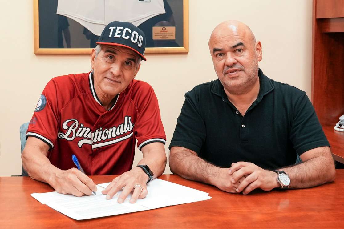 Dan Firova signs his contract beside Tecolotes de los Dos Laredos club president Chara Mansur in October 2026