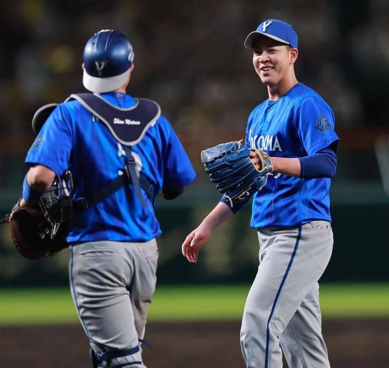 Kentarō Taira smiles with catcher Shion Matsuo after pitching against the Hanshin Tigers