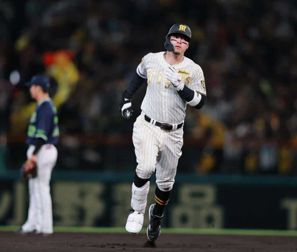 Teruaki Sato rounds the bases after hitting a home run for the Hanshin Tigers